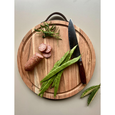 Stort rundt skærebræt med til pizza og kød.